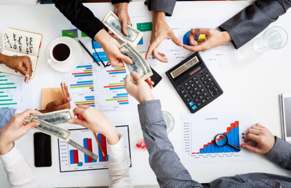 Picture of businessmen's hands on white table with documents, coffee and drafts